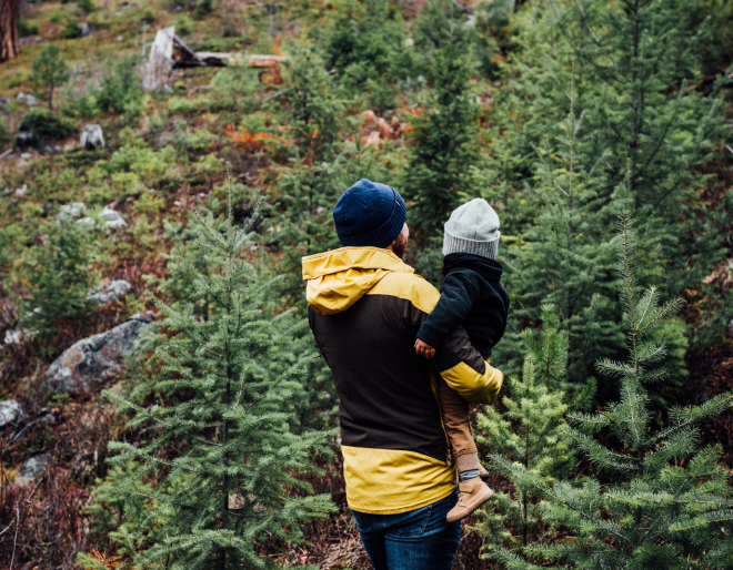Vater mit Kind im Arm im Wald